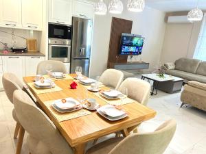 a dining room table and chairs in a living room at Green Residence by the beach in Golem