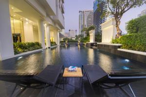 une chambre avec deux chaises et une table dans un bâtiment dans l'établissement Grande Centre Point Ploenchit, à Bangkok