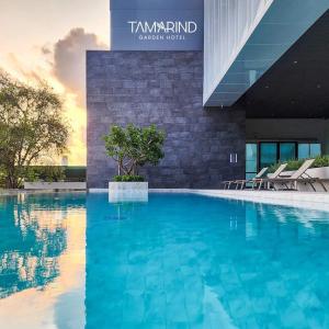 uma grande piscina em frente a um edifício em Tamarind Garden Hotel - SHA Plus Certified em Rayong