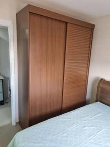 a wooden closet in a bedroom with a bed at CURTAS DIÁRIAS E ACIMA DE 28 DIAS VALOR MENOR ver in Sao Paulo