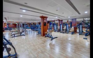 a gym with a lot of treadmills and machines at Metropolitain Dubai Hotel - Guest Room - UAE in Dubai