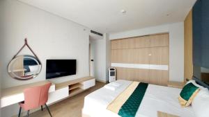 sypialnia z łóżkiem, telewizorem i krzesłem w obiekcie Sweet Home - Duplex 3BRS Citadines Hạ Long w Ha Long