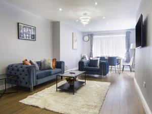 una sala de estar con sofás azules y una mesa. en Luxe 5 Bed Bungalow In Snodland, Medway, Kent en Kent