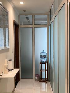 a room with a glass door with a clock on a shelf at Private Master-room in Vinhome, near Downtown in Ho Chi Minh City