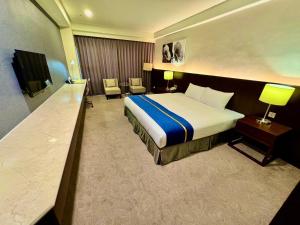 une chambre d'hôtel avec un lit et une télévision dans l'établissement HiYesHotel勤天商旅-花蓮館, à Hualien