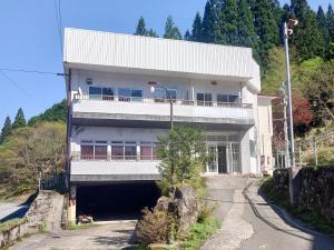 een groot wit gebouw met een garage ervoor bij Hachikita U Base in Kami