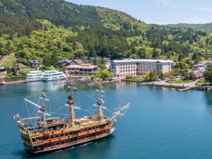 a large boat in the water near a city at Hakone Hotel in Hakone