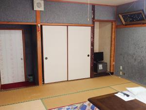 香美町的住宿－Hachikita U Base，一间设有三扇推拉门和一张桌子的房间