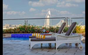 a patio with a table and chairs and a view of a city at Metropolitain Dubai Hotel - Junior Suite - UAE in Dubai