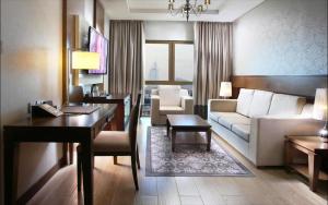 a living room with a couch and a table at Metropolitain Dubai Hotel - Junior Suite - UAE in Dubai
