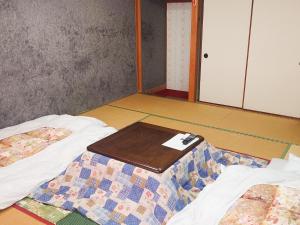een kamer met twee bedden en een tafel erop bij Hachikita U Base in Kami