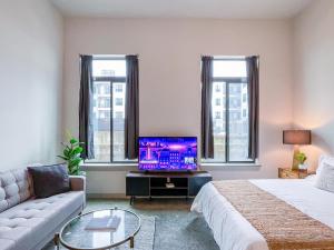 a living room with a bed and a tv at Monthier Suite Downtown Austin in Austin