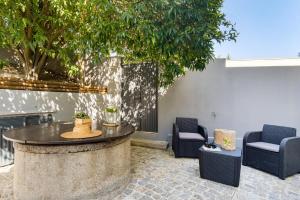 a patio with a table and chairs and a tree at Casa de Arouca - Arouca Suítes in Arouca