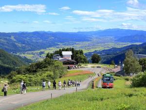 a group of people walking down a road with a bus at Yuzawa Toei Hotel in Yuzawa