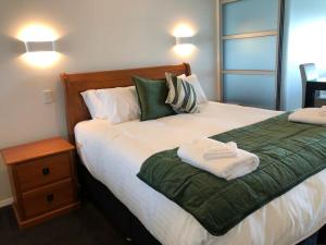 1 dormitorio con 1 cama grande con manta verde en Spacious Executive Apartmt,great Views! Location en Auckland
