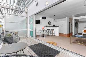 a large living room with a table and chairs at Funky One Bedroom Apartment on Princes Wharf in Auckland
