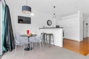 a kitchen and dining room with a table and chairs at Funky One Bedroom Apartment on Princes Wharf in Auckland
