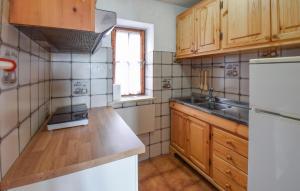 a kitchen with wooden cabinets and a white refrigerator at Gorgeous Home In Serrone With Wifi in Serrone