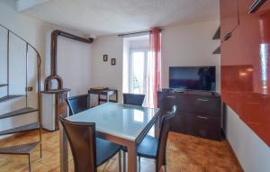 a dining room with a table and a television at 2 Bedroom Lovely Home In Serrone in Serrone