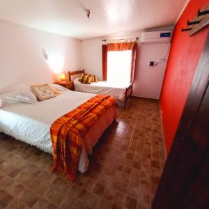 a hotel room with two beds and a window at Solar de Campo in Villa Elisa