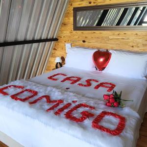 uma cama com uma placa que diz amor em Cabana Vale Encantado em São Bento do Sapucaí