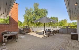un patio con mesa y sombrilla en 3 Bedroom Amazing Home In Fars en Hvalpsund