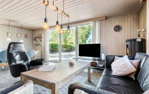 a living room with a couch and a table at 3 Bedroom Amazing Home In Fars in Hvalpsund