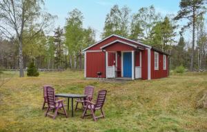 einen Tisch und Stühle vor einem roten Schuppen in der Unterkunft Gorgeous Home In Jmj With Kitchen in JÃ¤mjÃ¶