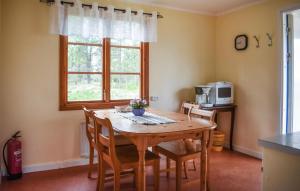 eine Küche mit einem Holztisch mit Stühlen und einer Mikrowelle in der Unterkunft Gorgeous Home In Jmj With Kitchen in JÃ¤mjÃ¶