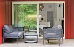 a living room with two chairs and a table at 3 Bedroom Lovely Home In Melby in Melby