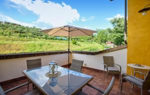 patio ze szklanym stołem i parasolem w obiekcie Cozy Apartment In Santa Maria A Monte w mieście Santa Maria a Monte