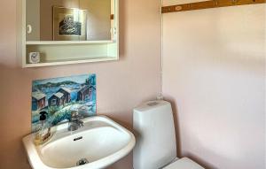 uma casa de banho com um lavatório, um WC e um espelho. em 2 Bedroom Nice Home In Norrtlje em Norrtälje