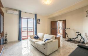 a living room with a couch and a balcony at Cozy Apartment In Messina With House Sea View in Briga Marina