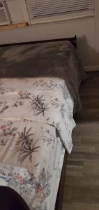 a bed with a comforter with flowers on it at Private Studios Orlando in Orlando