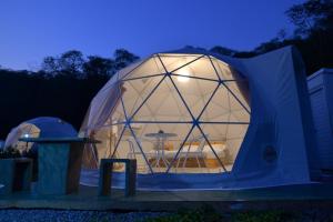 a large dome tent with a table in it at night at NiNo San Glamping - Pak Chong in Pak Chong