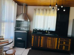 uma cozinha com um balcão, um lavatório e uma janela em Recanto Ar da Serra em São Joaquim