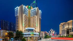 duży budynek z flagą na górze w obiekcie Holiday Inn Kunming City Centre, an IHG Hotel w mieście Kunming
