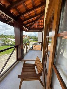 a wooden bench sitting on a porch with a window at Casa Aconchego - Barreirinhas in Barreirinhas