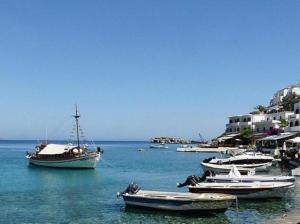 a group of boats in the water next to a beach at Maistrali in Loutro