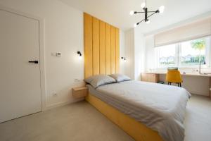 a bedroom with a large bed and a window at Miodowy apartament z dużym tarasem w Rewalu, blisko morza in Rewal +21 photos