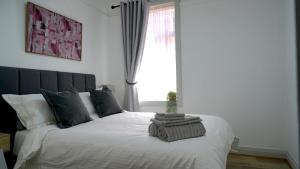 a bedroom with a large white bed with a window at Stay on Summer - CBD Apartment in Orange