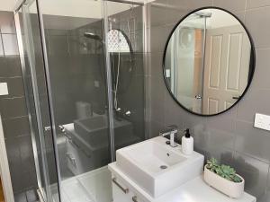 a bathroom with a sink and a mirror at Stay on Summer - CBD Apartment in Orange