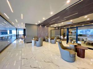 a lobby with chairs and tables in a building at Sky Elite Depto de lujo in Santa Cruz de la Sierra