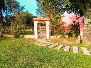 ein Tor in einem Hof mit Gras und einem Baum in der Unterkunft Solar de Campo in Villa Elisa