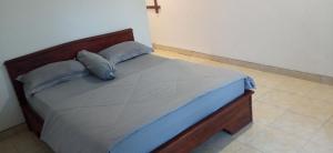 ein Bett mit einem hölzernen Kopfteil in einem Zimmer in der Unterkunft Tetebatu Fullmoon in Tetebatu