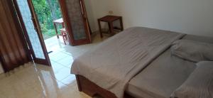 a bedroom with a bed in a room with a window at Tetebatu Fullmoon in Tetebatu
