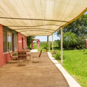 un patio con mesa y sillas bajo toldo en Solar de Campo en Villa Elisa