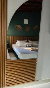 麦德林REST APARTMENT IN THE POBLADO的镜子中卧室的反射,镜子中的床