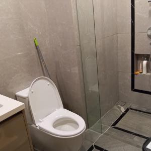 a bathroom with a toilet and a glass shower at Luxurious Apartement Lebak Bulus near MRT in Jakarta