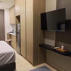a hotel room with a bed and a television on a wall at Luxurious Apartement Lebak Bulus near MRT in Jakarta
